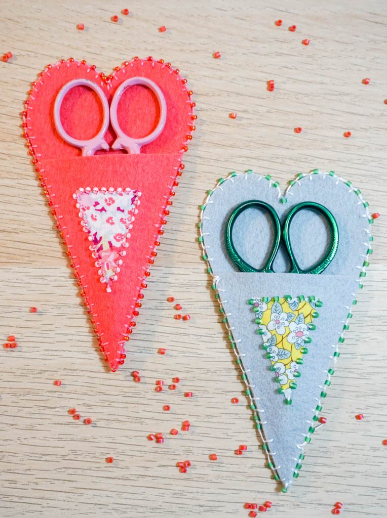 Child holds the scissors and cut out the felt flower. Scissors, hot glue  gun, sheets of felt, decorative pendant with felt butterflies and flowers  Stock Photo by ©OnlyZoia 115559608